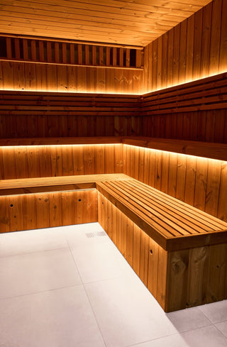 Wooden sauna interior with benches and warm lighting
